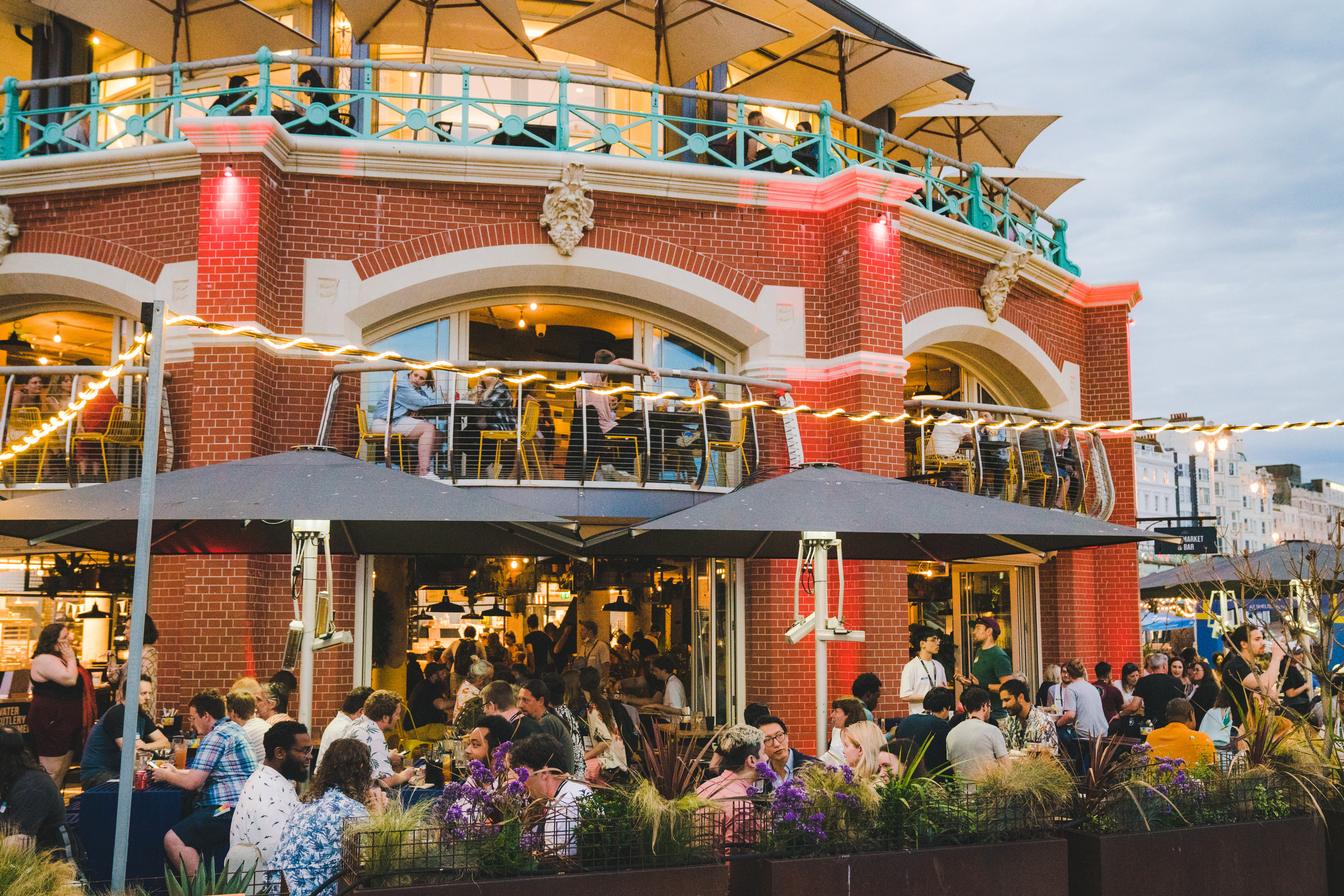 An image from last year's FOFE, showing the outside of the venue with many people enjoying the vibrant atmosphere, weather and food.